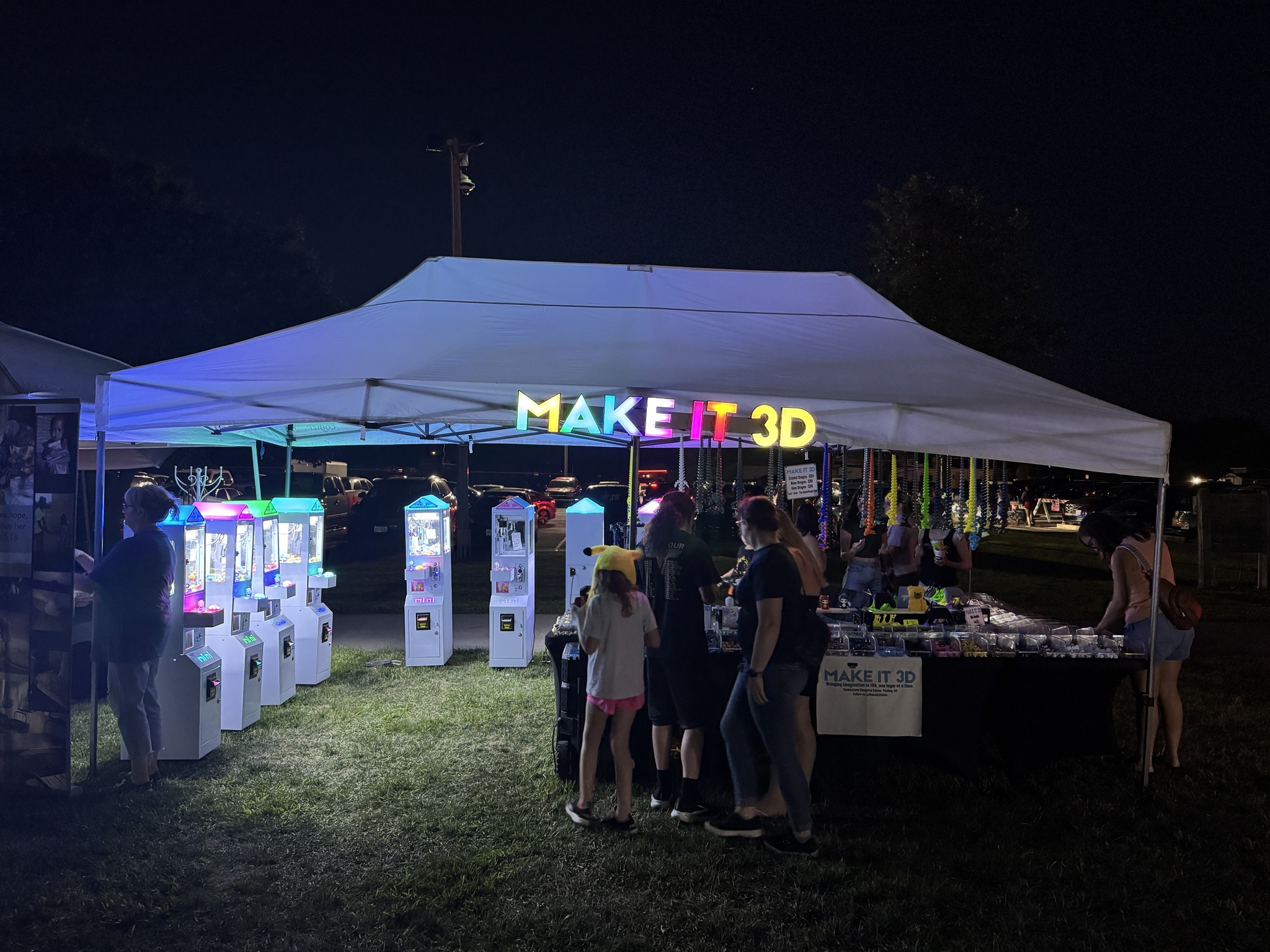 Make It 3D booth at a local event with claw machines and 3D printed products